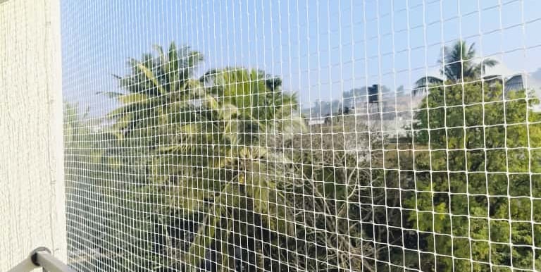 Close-up of a securely installed pigeon net on a residential balcony in Marathahalli.
