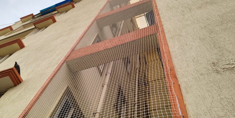 Wide shot showing pigeon nets covering apartment ducts to keep birds away.