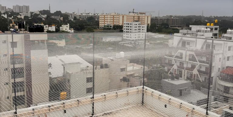 A technician carefully installing a sturdy sports net on a sunny Chennai terrace.