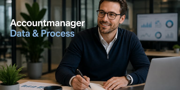A male account manager wearing glasses works on data and process management in a modern office.