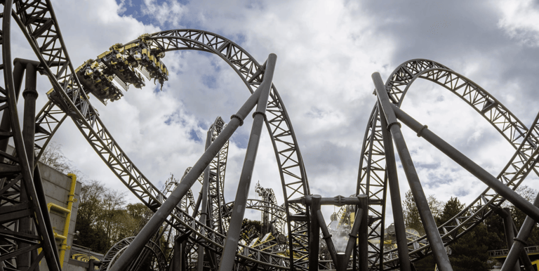 A Roller coaster in the shape of eyes and a smile with a cart on a loop to the left  