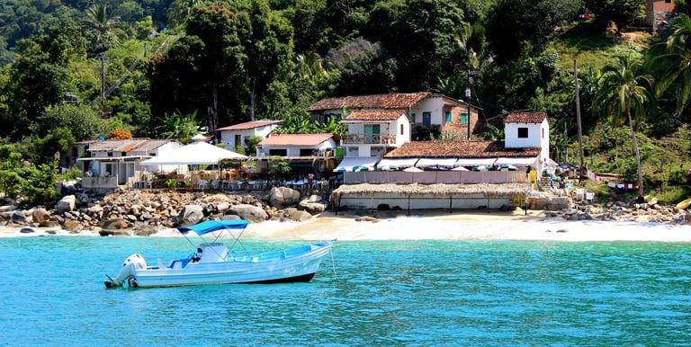 a boat in the water near a beach in Puerto Vallarta