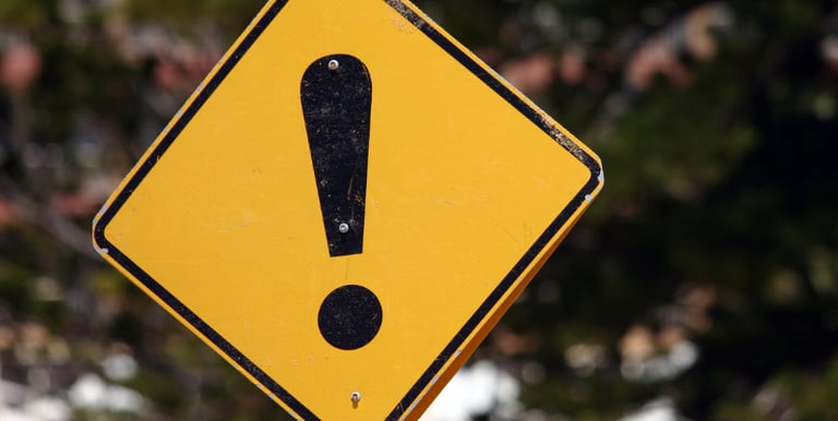 a yellow caution sign with a black and white exclamail