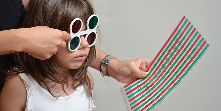 small girl using lens to read letters