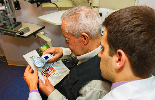 old man watching words through lens