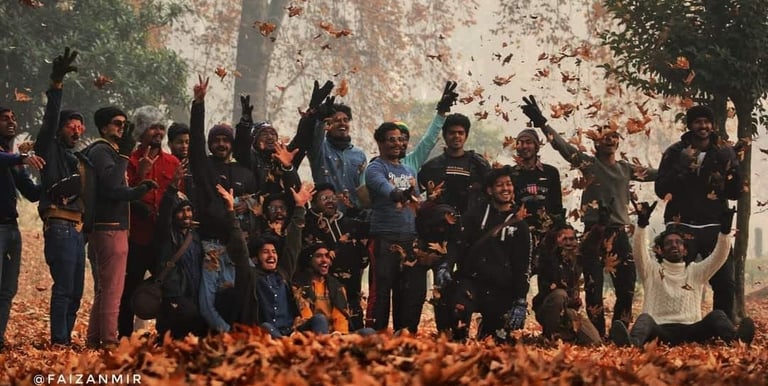 a group of tourists posing in autumn season in chinaar leaves during there kashmir trip  
