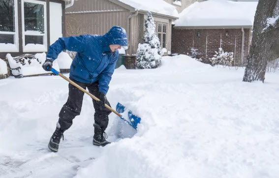 a person shoveling the snow from his driveway