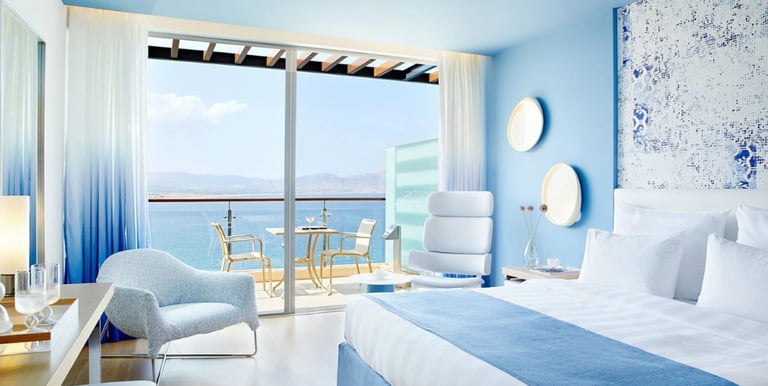 A spacious bedroom with a large bed and a balcony, symbolizing premium accommodation and comfort.