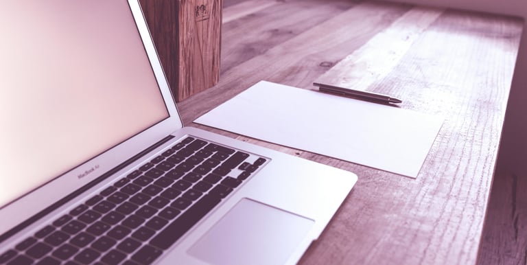 a laptop computer sitting on a wooden table
