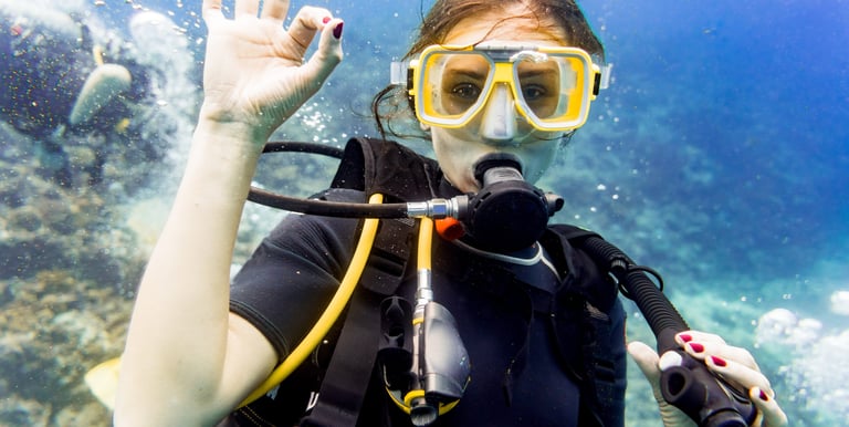 a woman in a scuba suit and goggles in the water