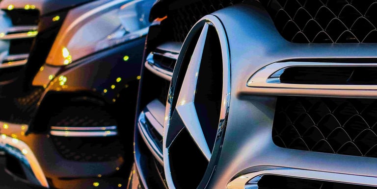 Close-up of Mercedes emblem on V-Class, showcasing premium transport services.