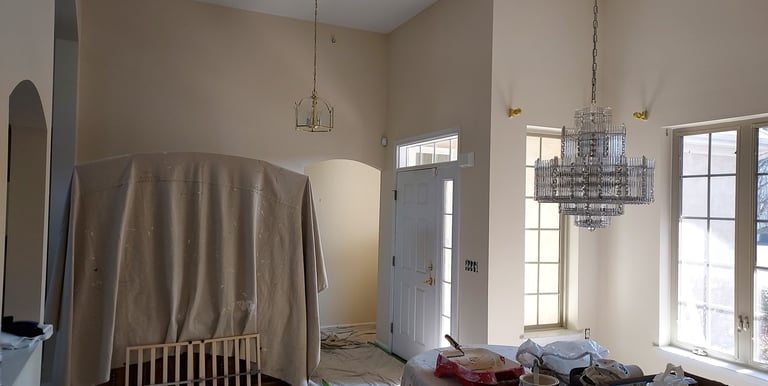 a dining room with drop clothes and paint trays