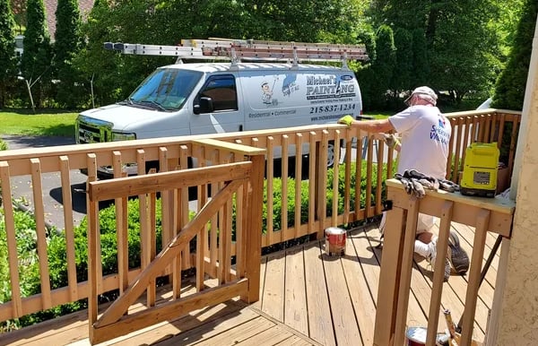 a man painting a deck with a van
