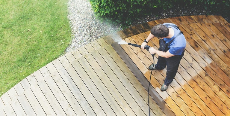 a man is using a pressurer to clean a deck deck