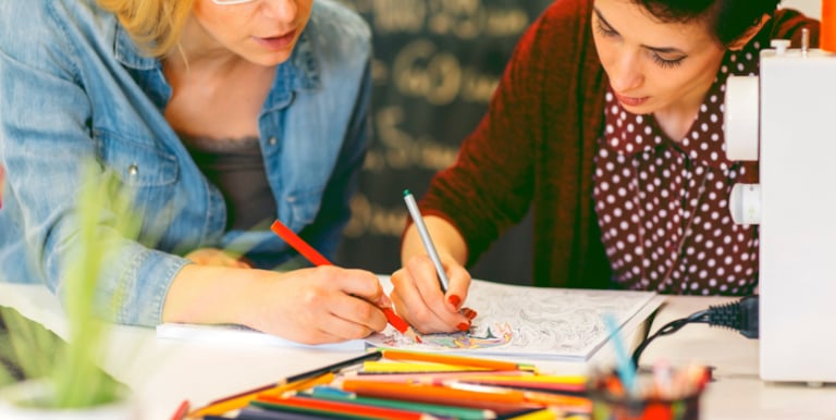 Women enjoying coloring pages from a coloring book