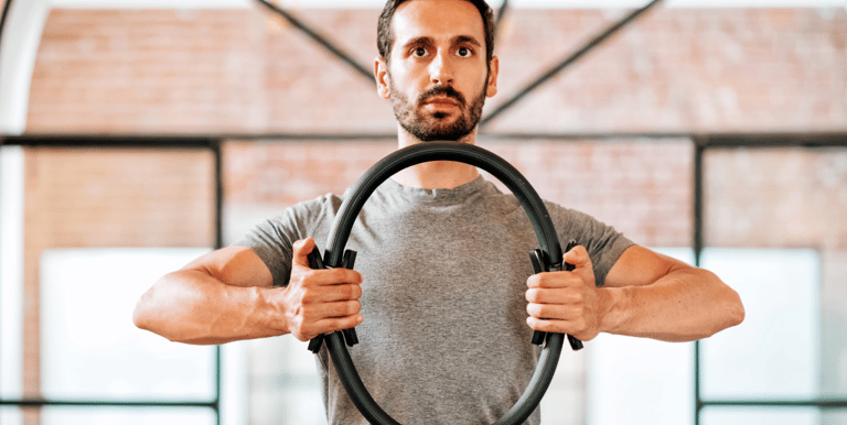 a man holding a pilates ring in his hands