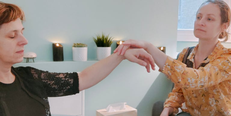 Une hypnothérapeute avec un chemisier jaune lève le poignet de sa cliente
