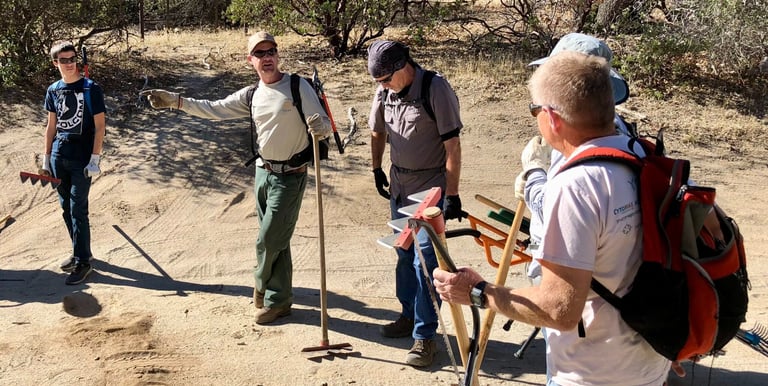 a group of people standing on a dirt road