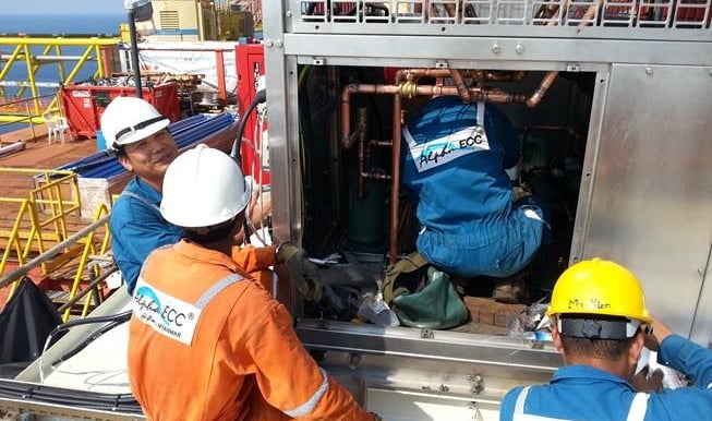 Alpha ECC technicians in safety gear performing HVAC maintenance on an offshore platform.