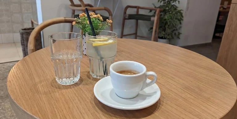 Café espresso y limonada servidos en una mesa de madera en KeP’s caffetteria, una cafetería