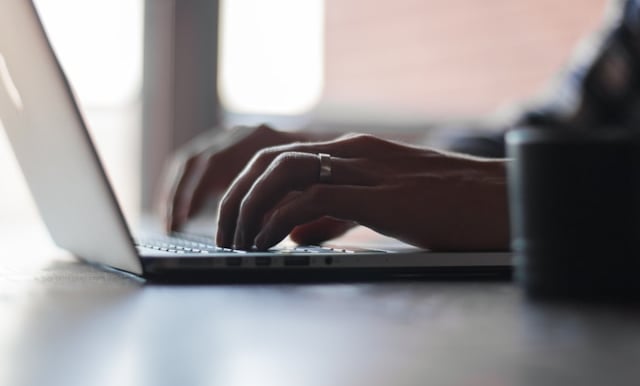 a person typing on a laptop computer