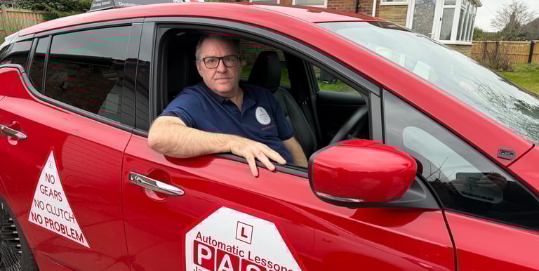 Professional instructor in a red car for automatic driving lessons at Jason's Driving School.