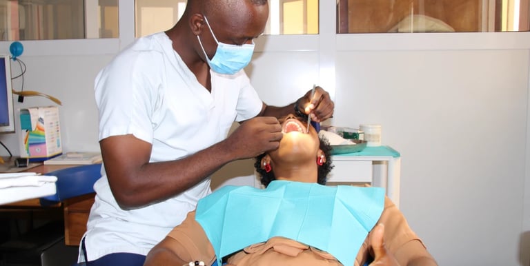 Un dentiste chirurgien effectuant un examen dentaire sur une patiente dans une clinique à Yaoundé.