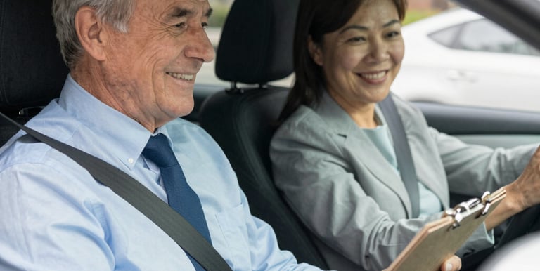 A friendly instructor guiding a teen driver through a quiet neighborhood street.