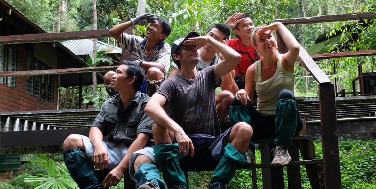  Traveller and guides sitting on a wooden deck resting while taking photos