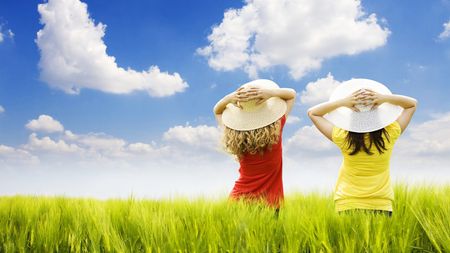 two women in hats standing in a field