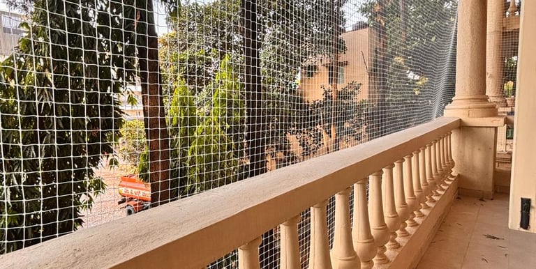 Close-up of a sturdy pigeon safety net securely installed on a Mumbai balcony.
