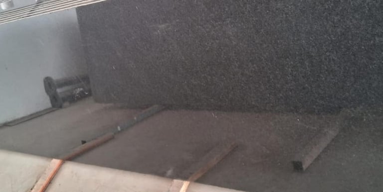 Polished black granite slabs with a mirror finish for kitchen countertops and flooring.