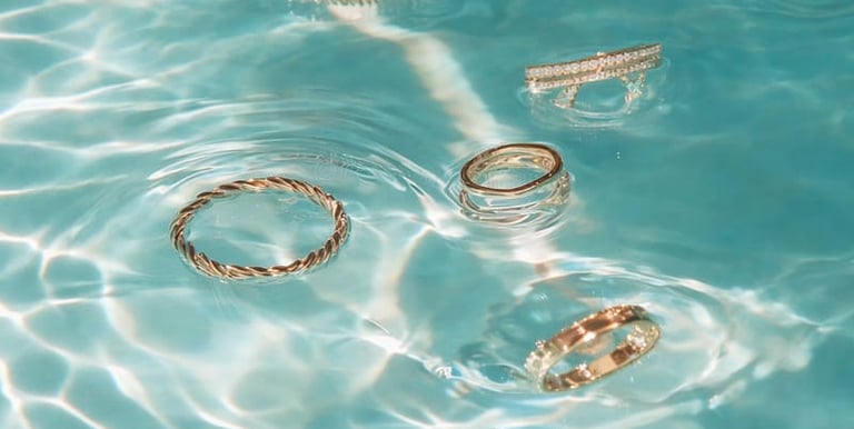 Anillos dorados minimalistas sumergidos en agua, joyería resistente diseñada para uso diario de Moreina Joyería.