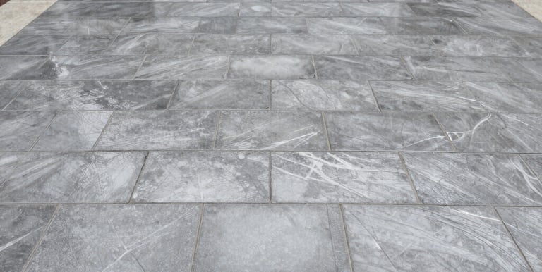 Before and after view of an interlock tile patio transformed by sealing.