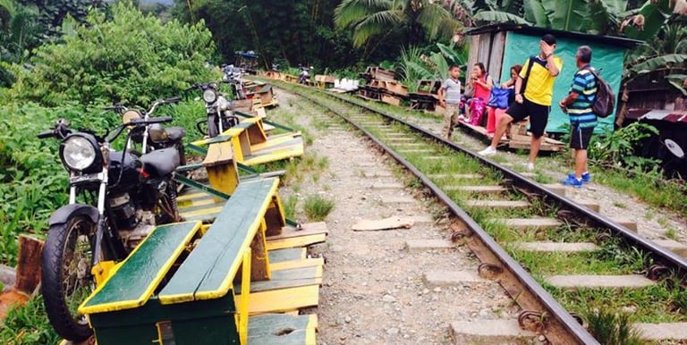 Trolley skates and motorcycles on rural railway tracks with local commuters.