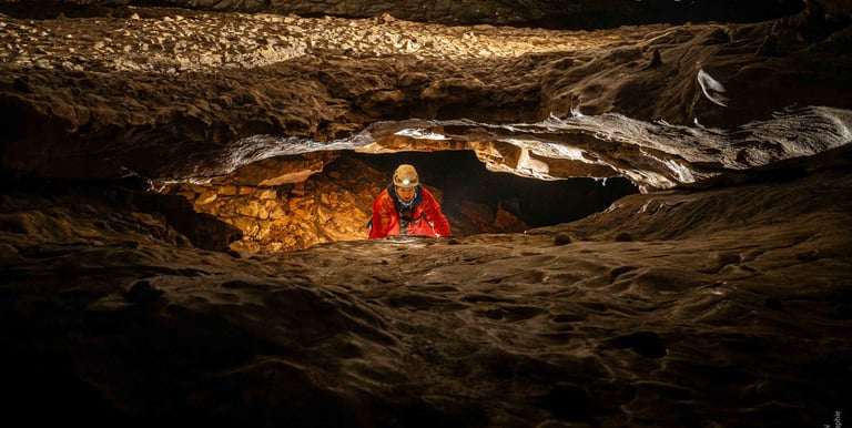 Un sujet au milieu d'une galerie en partie basse met en avant les croisements de galerie en spéléologie