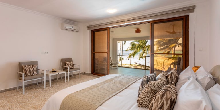 a bedroom with a bed and a couch and a ocean view in Zanzibar