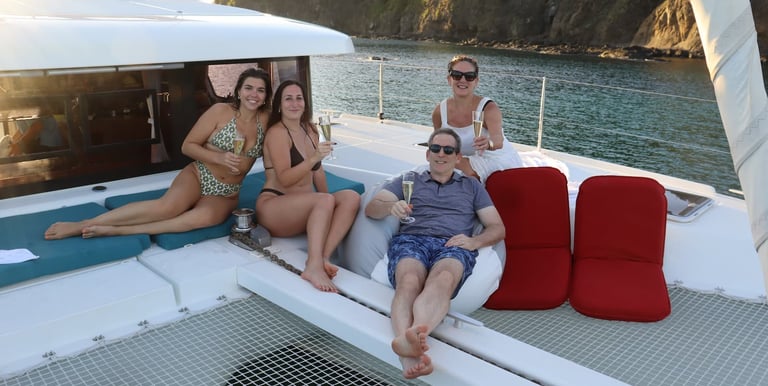 Guests relaxing with champagne on deck of luxury catamaran in Papagayo, Costa Rica