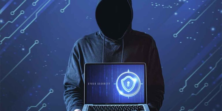 a person in a hoodie with a laptop computer