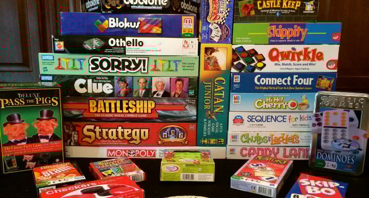 A wide selection of board games represented on a shelf.