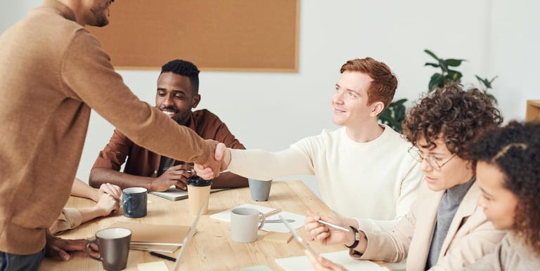 a man shaking hands with a woman in a meeting room