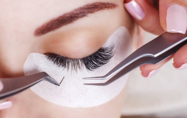 alt="mobile lash technician applying lashes in London home"