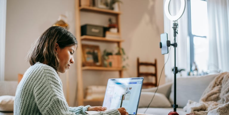 a woman sitting at a table with a laptop computer