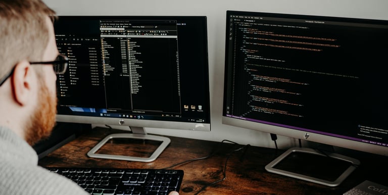 a man looking to a computer screen, looks like he is working on design of a website. 