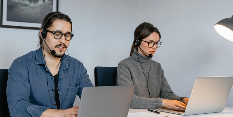 two people one male and one female are looking to the computers while setting looks like working.