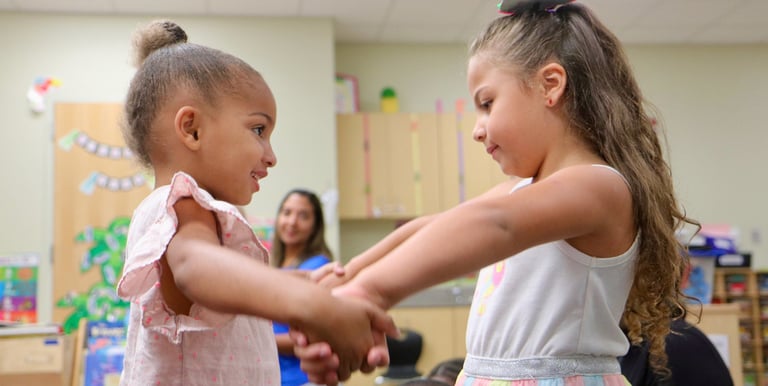 young girls holding hands and moving