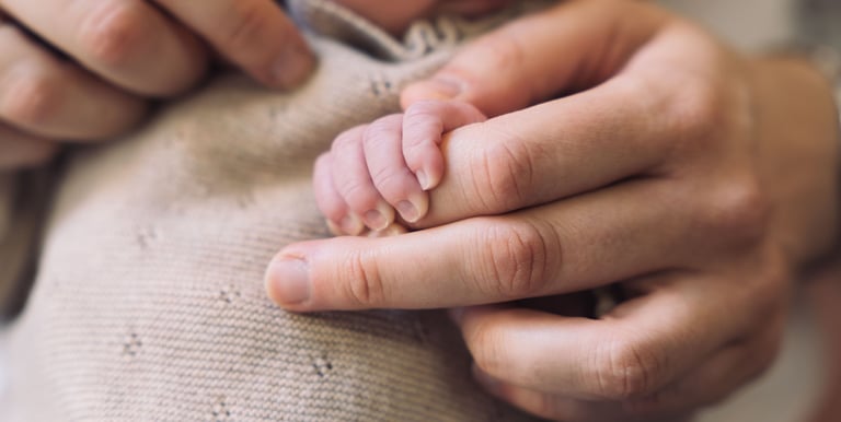Photographe naissance Paris 8 : gros plan mains maman et bébé