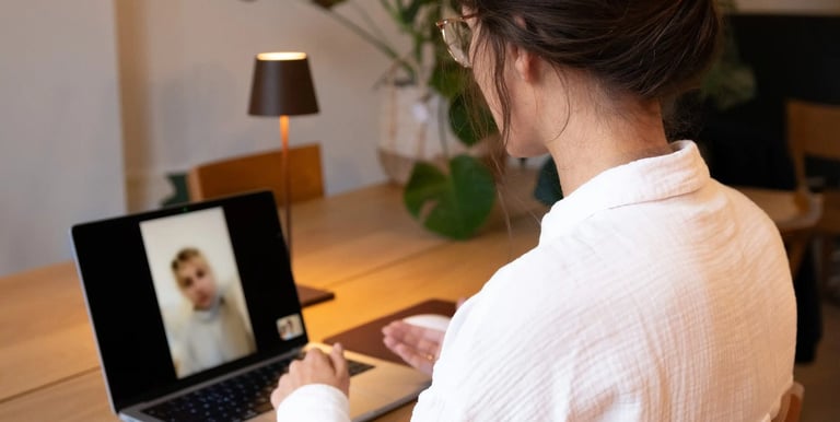 Psychologist at desk in video call with client on laptop, online psychological counseling