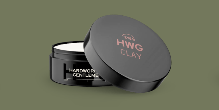 3D mockup of a black Hardworking Gentlemen Clay Pomade plastic container open on a green background.