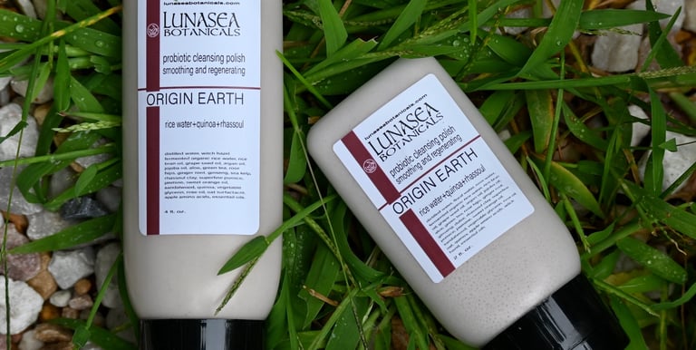 lunasea botanicals probiotic scrub 2 bottles laying in green grass